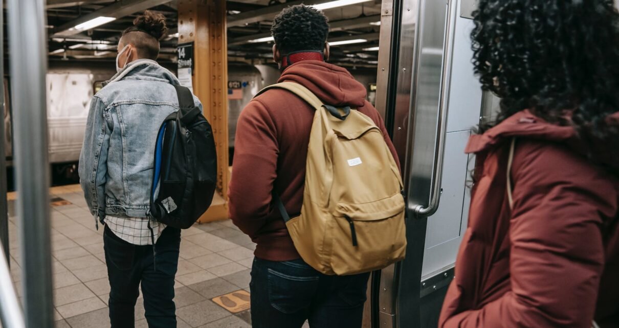 faceless multiethnic students walking out of subway train