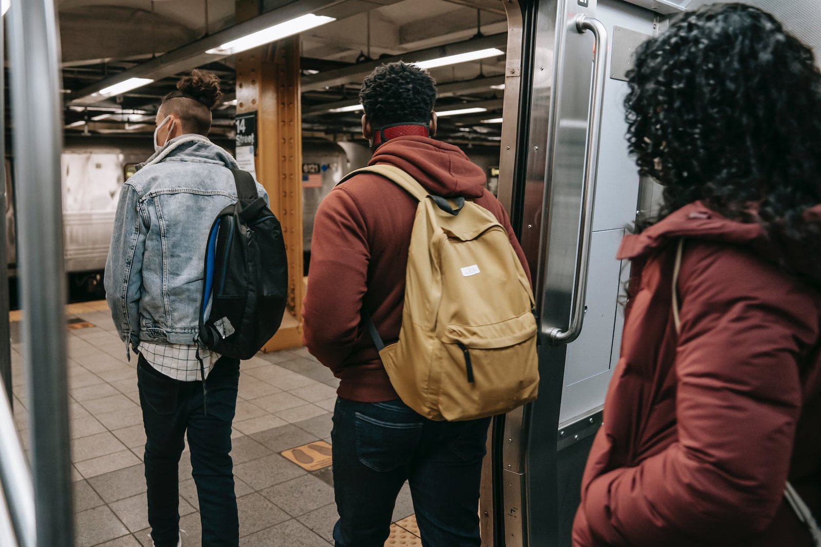 faceless multiethnic students walking out of subway train