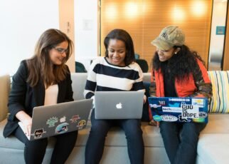 three woman in front of laptop computer