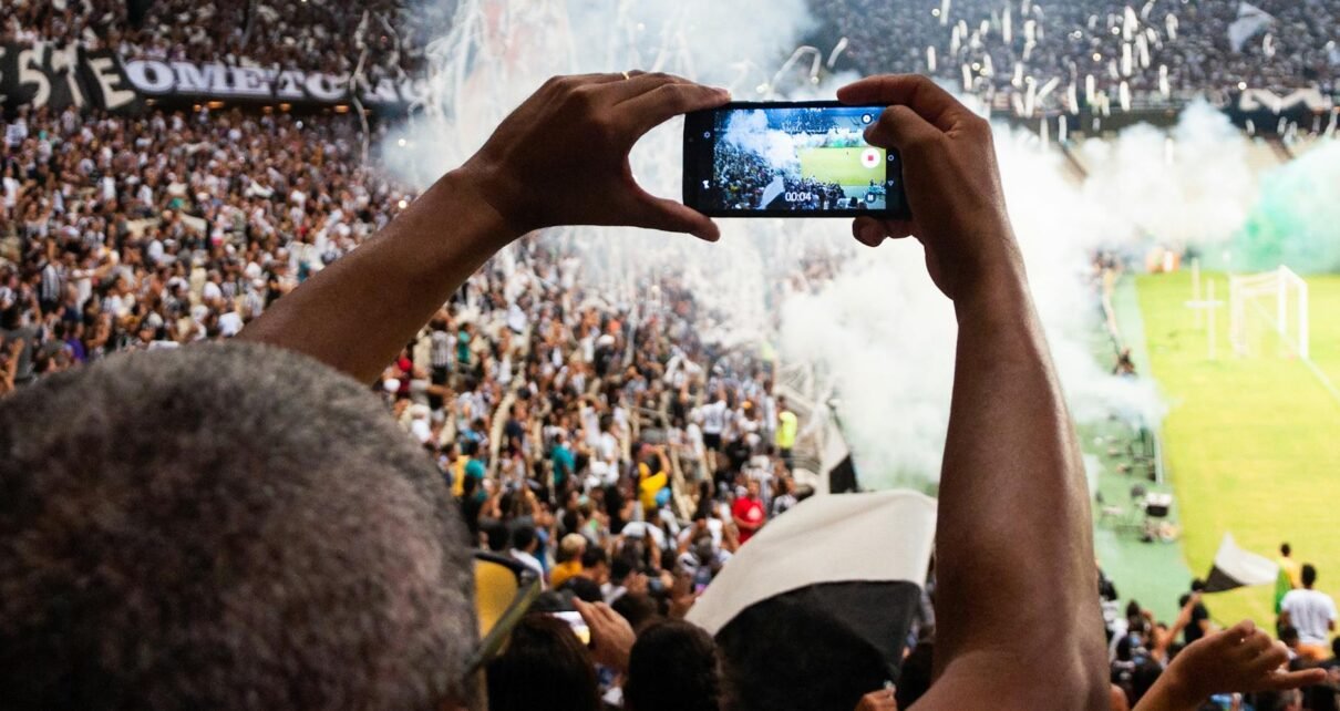 person taking photo of stage stadium presentation