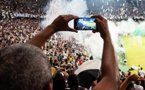 person taking photo of stage stadium presentation