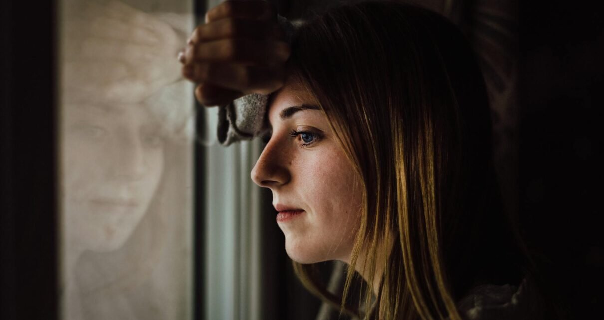 woman leaning on glass window