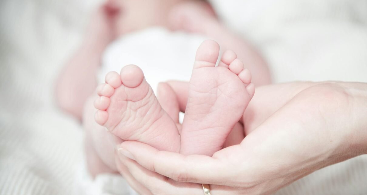 close up of hands holding baby feet