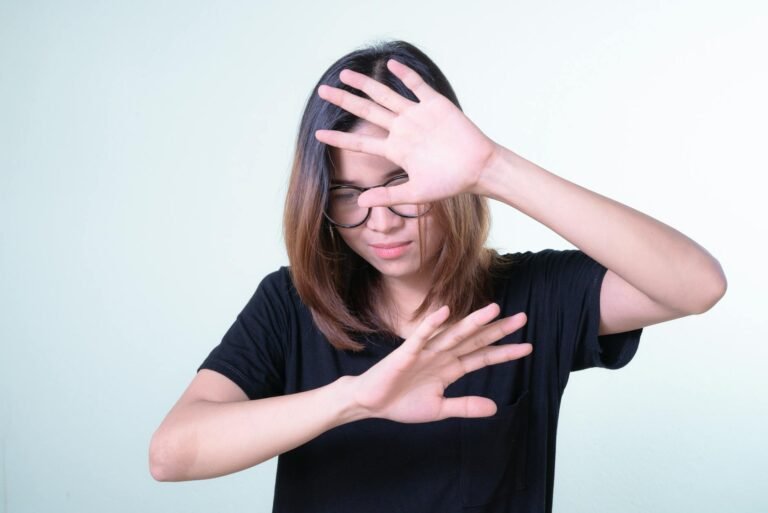 woman in black shirt covering face with her hands